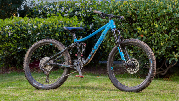 A blue Marin Bikes mountain bike parked on grass with green bushes background, HD Desktop Wallpaper