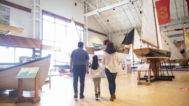 A family explores the Maritime Museum with various model boats on display, HD Desktop Wallpaper