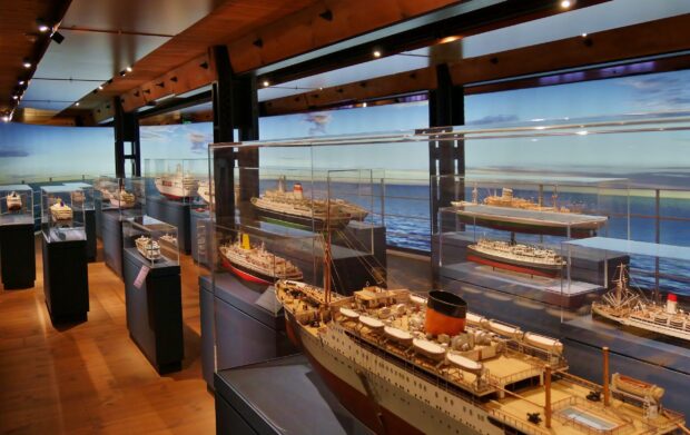 A collection of maritime museum model ships is exhibited under glass cases, 2K Desktop Wallpaper