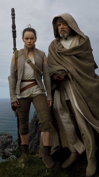 Mark Hamill and Daisy Ridley stand together in rugged clothing near a cliffside by the ocean, HD Mobile Wallpaper