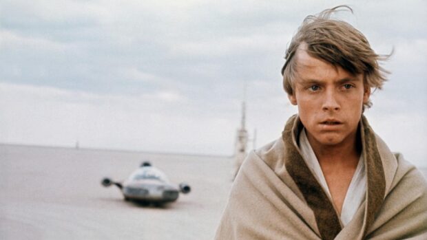 Mark Hamill stands wrapped in a cloak in a desert with a futuristic vehicle behind him, HD Desktop Wallpaper