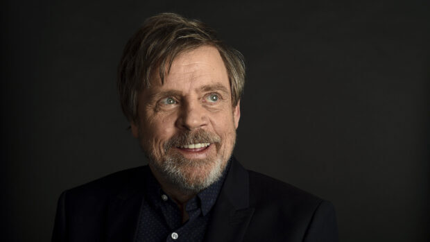 Mark Hamill smiles in a dark suit against a black backdrop, HD Desktop Wallpaper