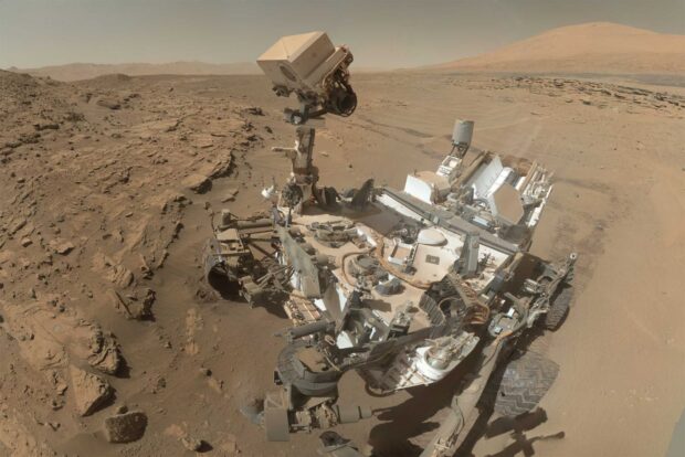 The Mars Curiosity Rover explores the rocky terrain on Mars under a dusty sky, HD Desktop Wallpaper