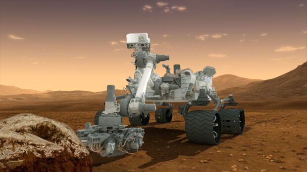 The Mars Curiosity Rover explores red rocky terrain under a soft orange sky, HD Desktop Wallpaper