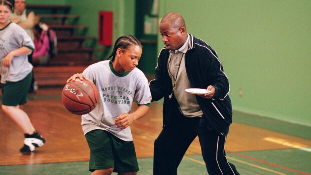 Martin Lawrence coaching a young player on basketball skills in a gym, 2K Desktop Wallpaper