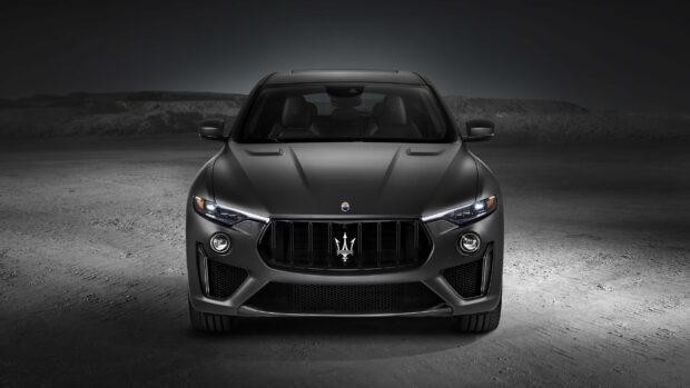 The Maserati Levante is shown in a matte black finish with illuminated headlights, 2K Desktop Wallpaper