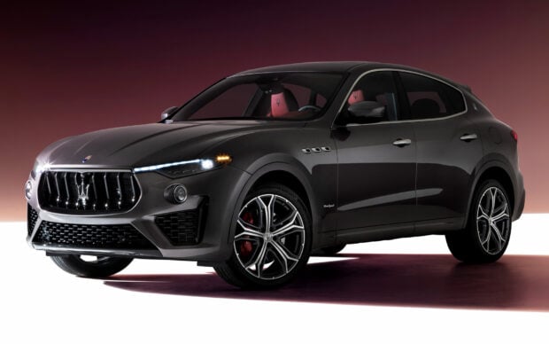 A dark gray Maserati Levante is shown with illuminated headlights and red interior seats, HD Desktop Wallpaper