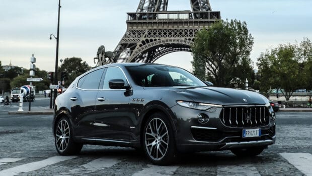 A Maserati Levante drives near the Eiffel Tower in a city setting, 4K Desktop Wallpaper