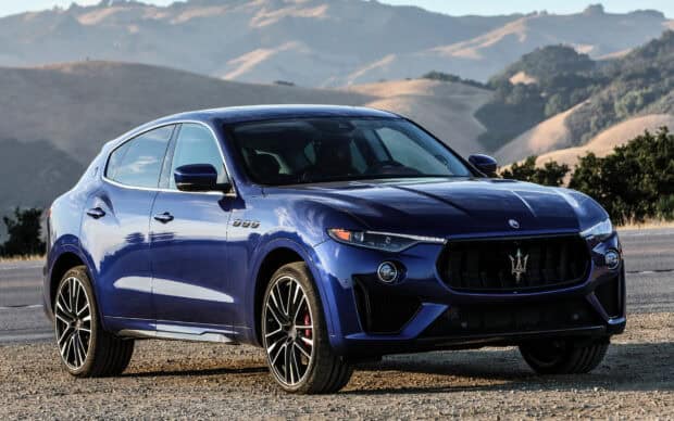 A blue Maserati Levante is parked on a road with hills in the background, HD Desktop Wallpaper