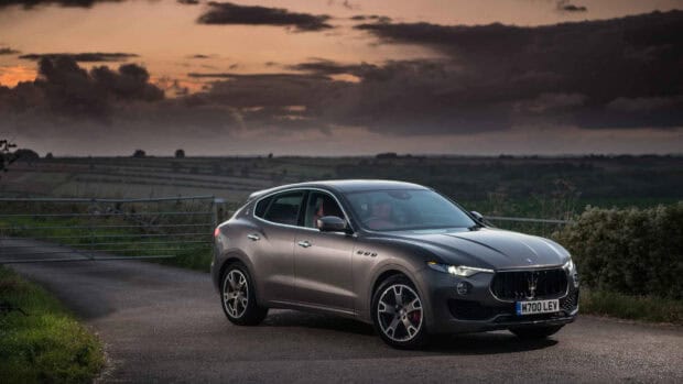 A Maserati Levante is parked on a rural road at dusk with dramatic clouds in the sky, HD Desktop Wallpaper