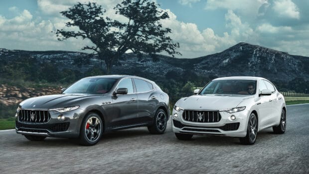 Two Maserati Levante vehicles parked on a road with mountains in the background, 4K Desktop Wallpaper