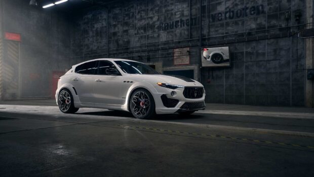 A white Maserati Levante is parked inside an industrial garage with concrete walls, HD Desktop Wallpaper