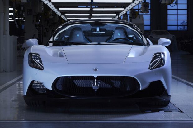 A sleek Maserati MC20 is parked inside a modern showroom with reflective floors, HD Desktop Wallpaper