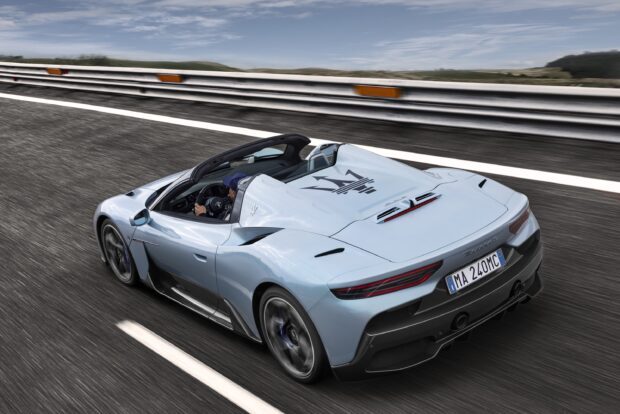 A blue Maserati MC20 is driving fast on a racetrack under a cloudy sky, 2K Desktop Wallpaper