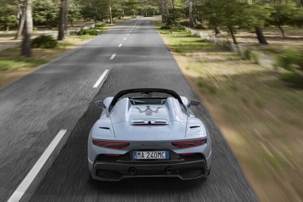 A Maserati Mc20 speeding down a tree lined street with motion blur on the sides, 2K Desktop Wallpaper