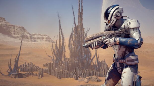 A soldier from Mass Effect Andromeda stands ready with a weapon in a desert landscape with alien structures, HD Desktop Wallpaper