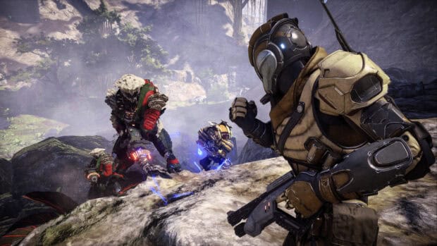 A soldier in advanced armor faces multiple alien enemies in a rocky environment, HD Desktop Wallpaper