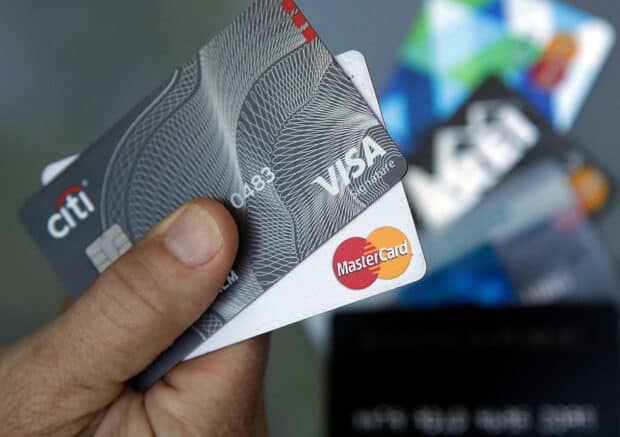 A hand is holding Mastercard and Visa cards with blurred cards in the background, HD Desktop Wallpaper