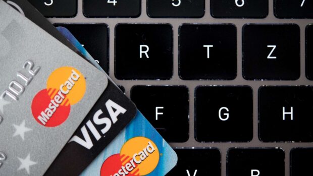 Two Mastercard credit cards placed on a black laptop keyboard showing the logo clearly, HD Desktop Wallpaper