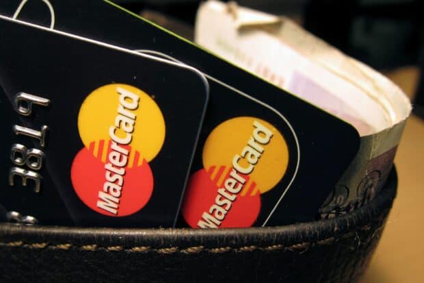 Two Mastercard cards are placed inside a black leather wallet with banknotes visible, HD Desktop Wallpaper
