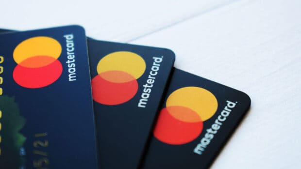 Several credit cards with the Mastercard logo are displayed on a white surface, HD Desktop Wallpaper