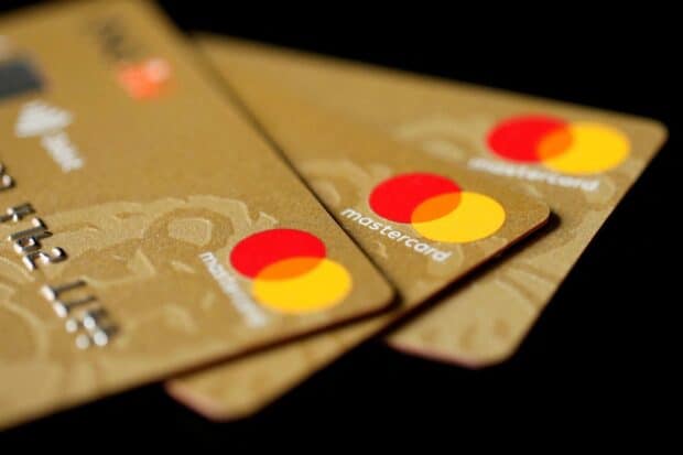 A close up of Mastercard displaying the iconic red and yellow logo on gold cards, HD Desktop Wallpaper