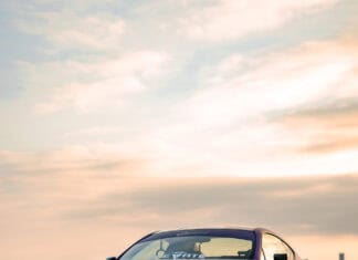 A matte purple Subaru Brz is parked on a concrete surface with a cloudy sky at sunset, 2K Mobile Wallpaper