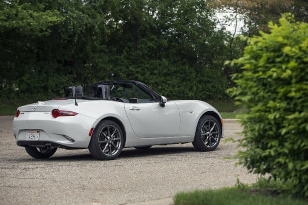 A white Mazda MX 5 Miata convertible is parked on a quiet road with green trees in the background, HD Desktop Wallpaper