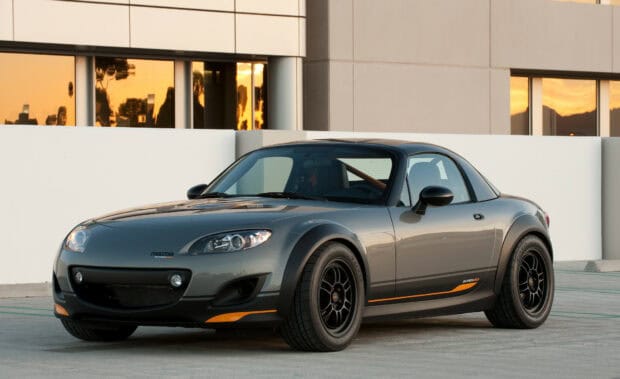 A grey Mazda MX 5 Miata is parked near a building with reflective windows at sunset, HD Desktop Wallpaper