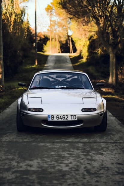 A white Mazda MX 5 Miata is parked on a tree lined road during autumn, HD Mobile Wallpaper