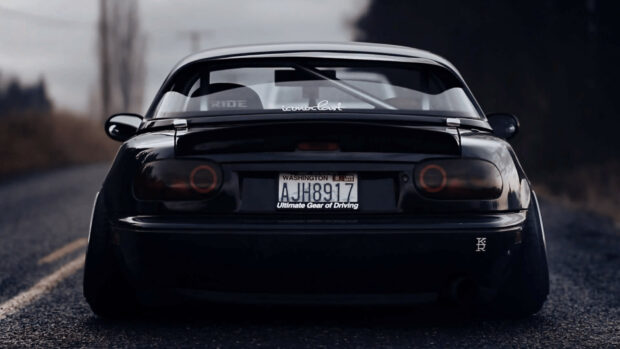A black Mazda MX 5 Miata is parked on a road with a blurred background, HD Desktop Wallpaper
