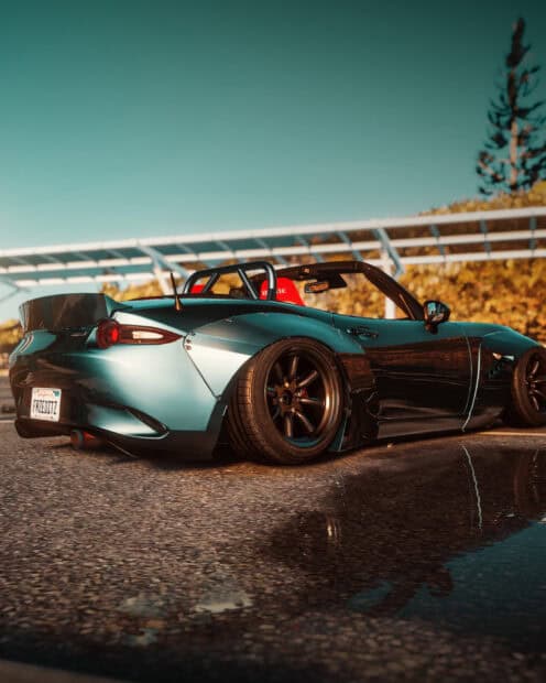 A customized Mazda MX 5 Miata parked near a reflective puddle under clear sky, 2K Mobile Wallpaper