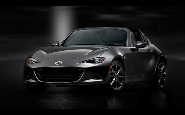 A sleek black Mazda Mx 5 Miata is showcased in a dark setting highlighting its design, 2K Desktop Wallpaper