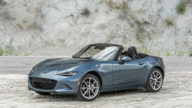 A blue Mazda Mx 5 Miata parked on a gravel area beside a rocky wall, HD Desktop Wallpaper