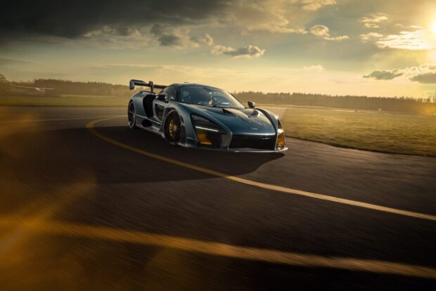 A McLaren Senna car is driving fast on a racetrack under a cloudy sky, 2K Desktop Wallpaper