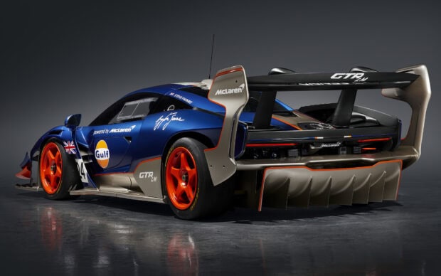 The McLaren Senna racing car features a blue body with orange wheels and a large rear wing, HD Desktop Wallpaper