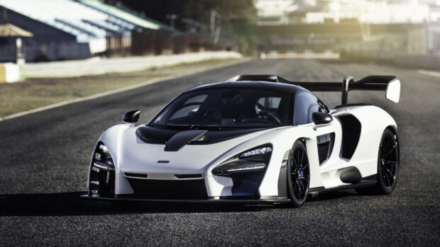 A white McLaren Senna is parked on a racing circuit with a blurred background, 2K Desktop Wallpaper
