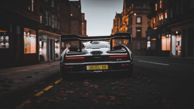 A McLaren Senna is parked on a city street surrounded by autumn leaves in this image, HD Desktop Wallpaper