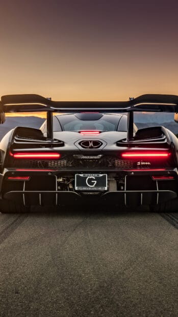 The McLaren Senna showcases its aerodynamic design from the rear during sunset, 4K Phone Wallpaper