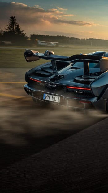 A McLaren Senna car is driving fast on a road with dust trailing behind, 4K Mobile Wallpaper