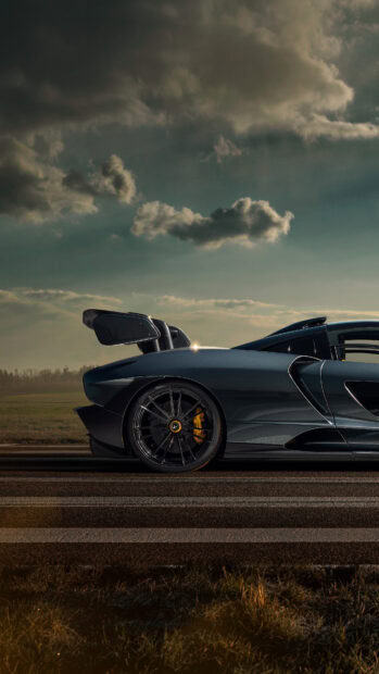 A dark McLaren Senna is captured from the side under a cloudy sky, 4K Phone Wallpaper