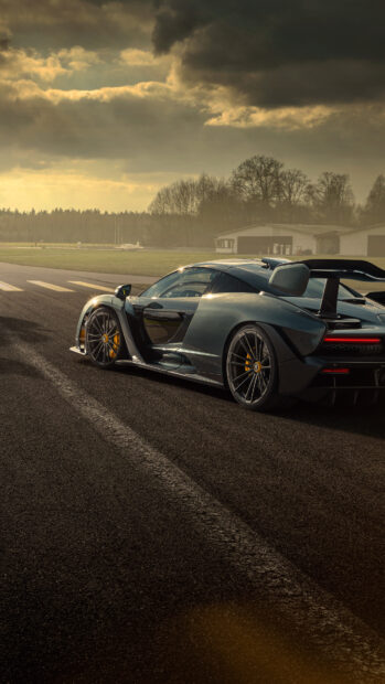 A McLaren Senna car is parked on an empty asphalt track under a cloudy sky, 4K Phone Wallpaper
