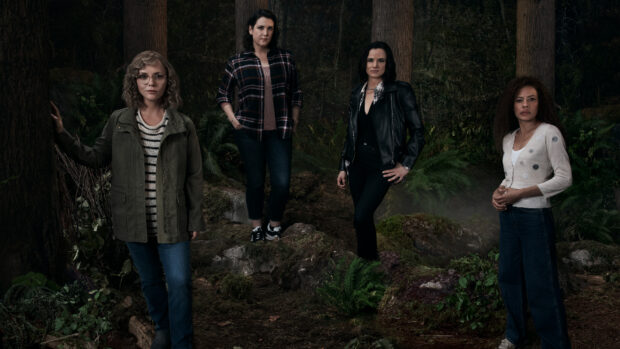 Melanie Lynskey and other women stand in a dimly lit forest with dense foliage, HD Desktop Wallpaper