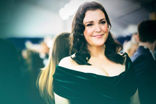 Melanie Lynskey smiles warmly at a social event in a dark green dress, HD Desktop Wallpaper