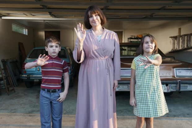 Melanie Lynskey is smiling and waving with two children in a garage setting, 2K Desktop Wallpaper