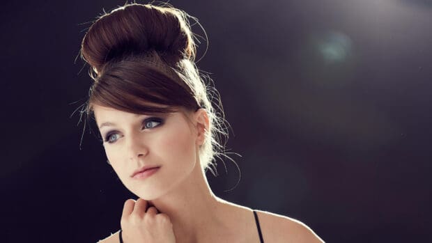 Melissa Benoist looks thoughtful with a stylish updo against a dark background, 4K Desktop Wallpaper