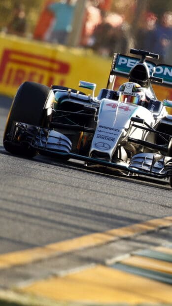 A Mercedes AMG F1 car races on a circuit with vivid sponsor signs, HD Mobile Wallpaper