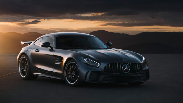 A Mercedes Benz AMG GT is parked with mountains and dramatic sunset sky in the background, 4K Desktop Wallpaper