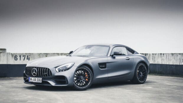 A gray Mercedes Benz AMG GT sports car parked near a concrete wall, 4K Desktop Wallpaper