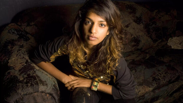 Mia rapper sitting with folded arms on a patterned sofa looking at the camera, HD Desktop Wallpaper